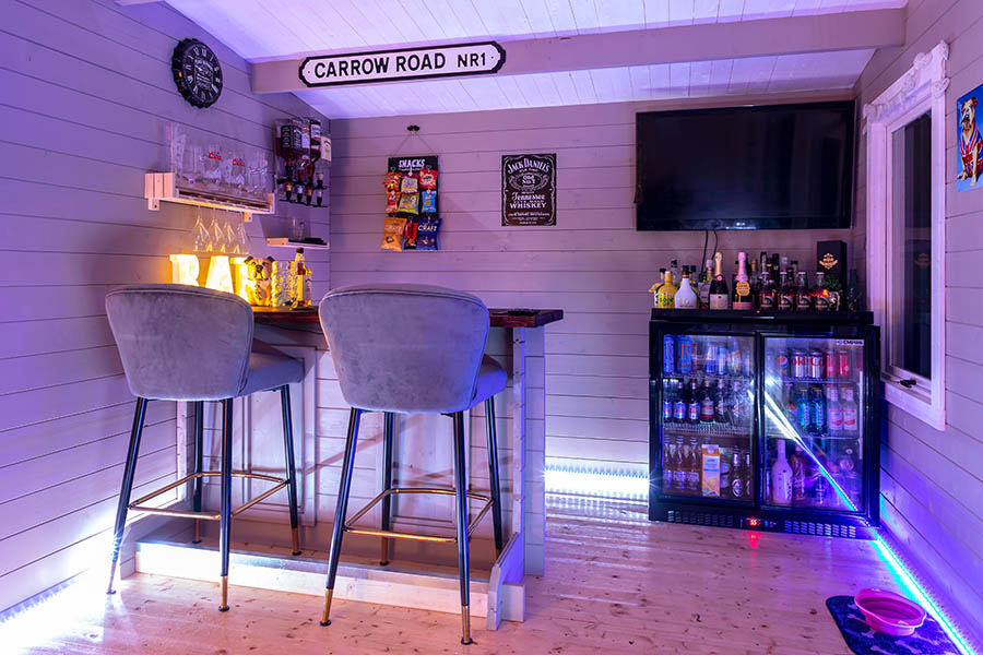 home bar with tv and neon sign
